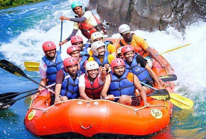 Group of adventurers river rafting through the rapids near Magenta Resort in Dandeli